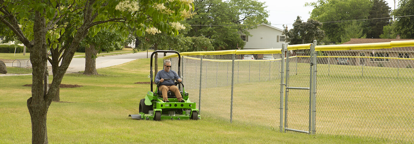 Person mowing lawn on a riding lawnmower